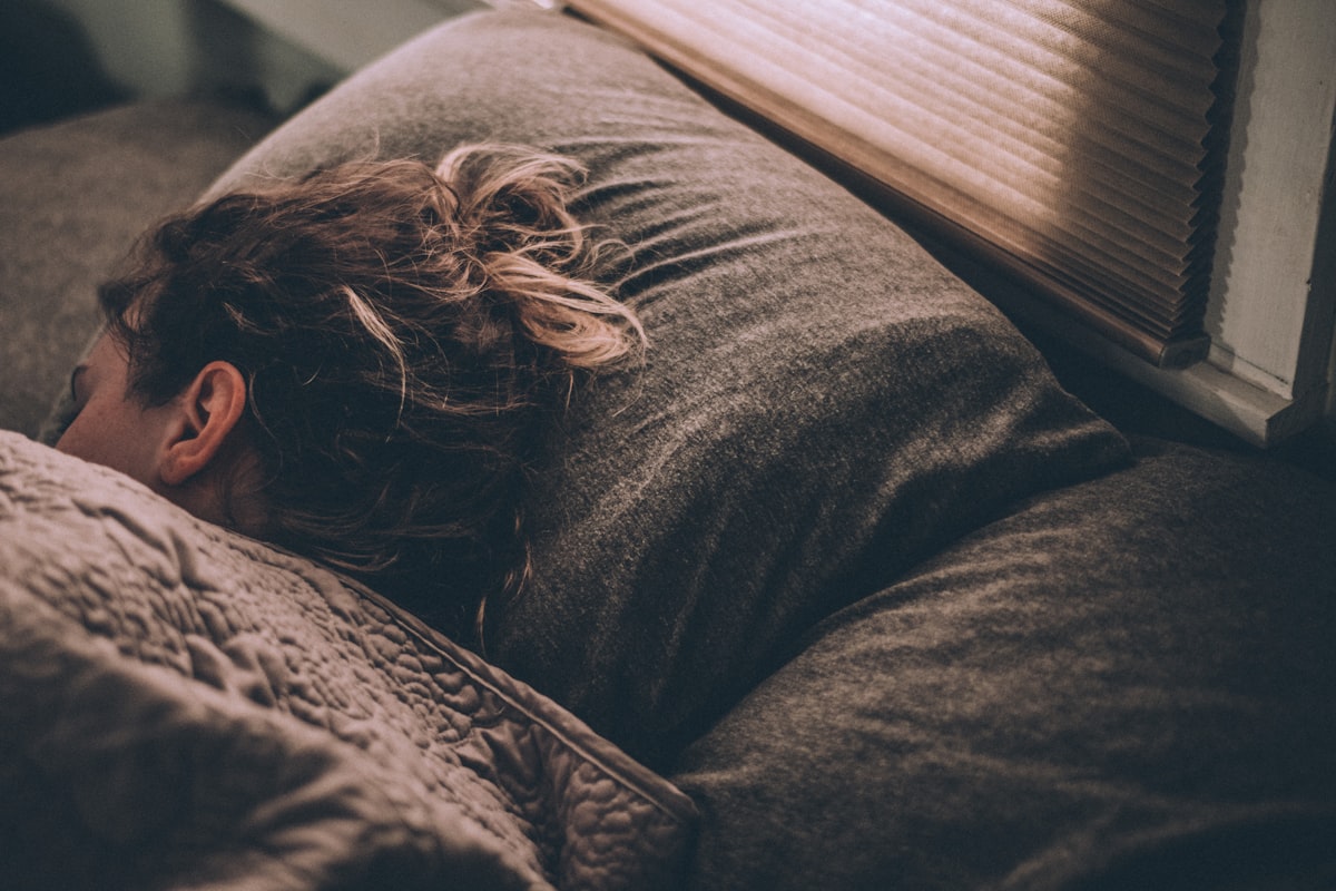 Woman sleeping peacefully in bed under warm morning light